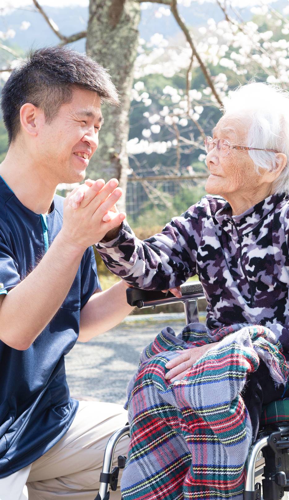 お兄さんとおばあさんが手をつないでいる様子