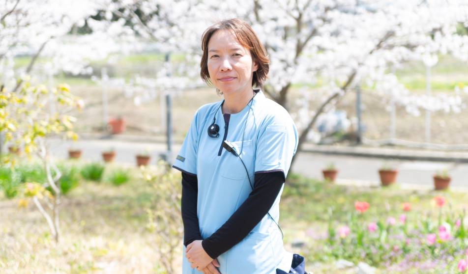 桜の下で写真をとる看護師
